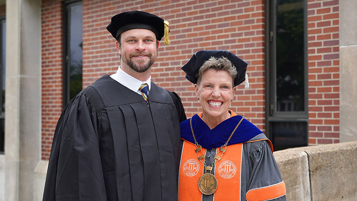 Brian Daniels and Linda Martin wearing graduation robes.