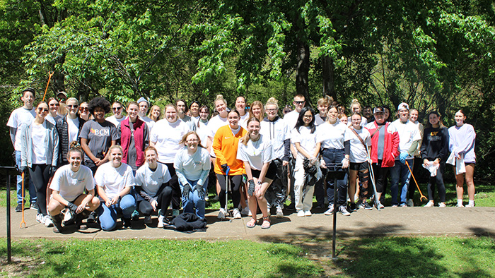 A group of students pose for a group photo next to a local creek in Pulaski, Tennessee.