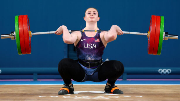 A young, white female clean lifting at the 2024 Olympics.