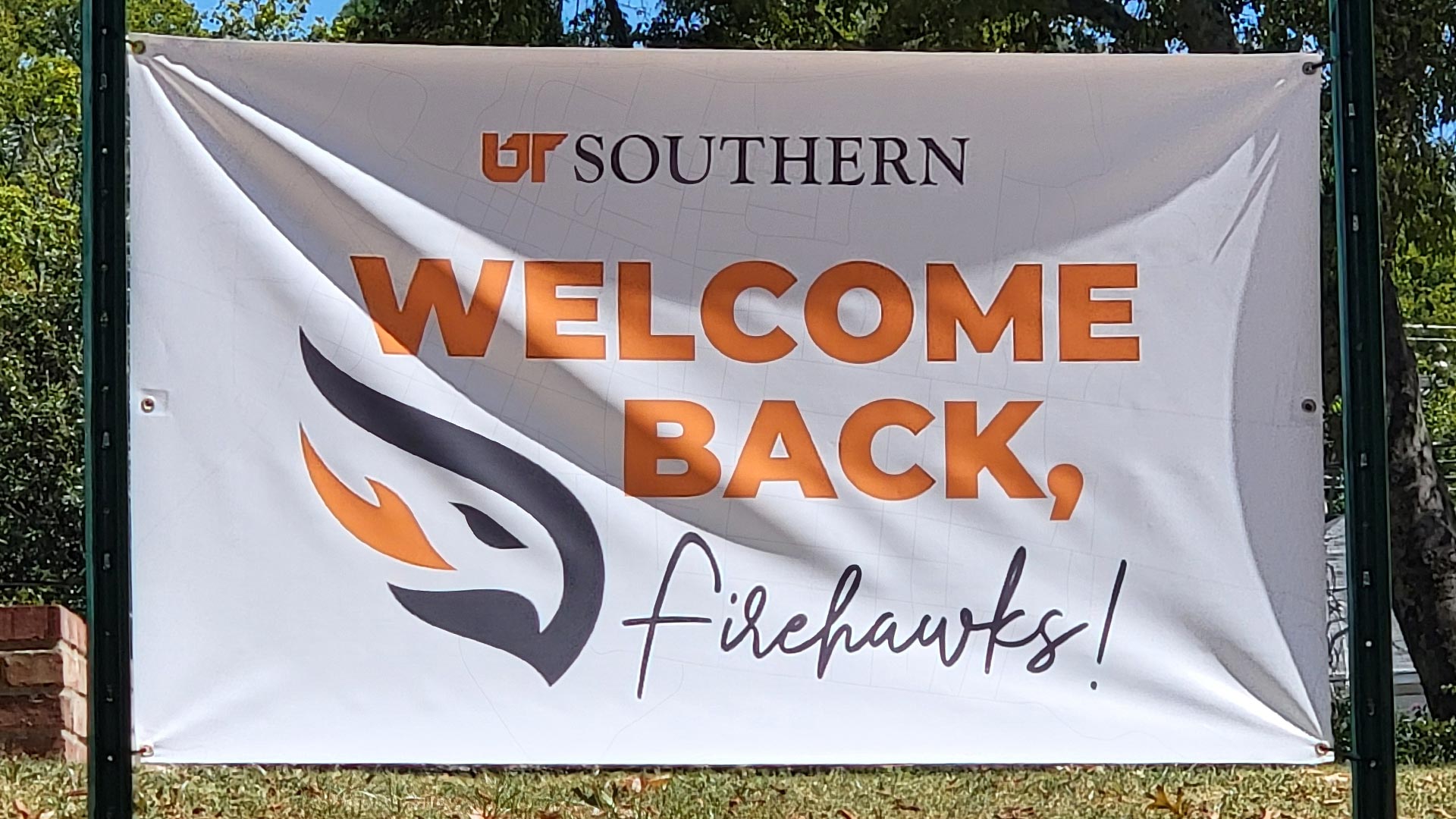 A white vinyl banner displaying a welcome back students message.