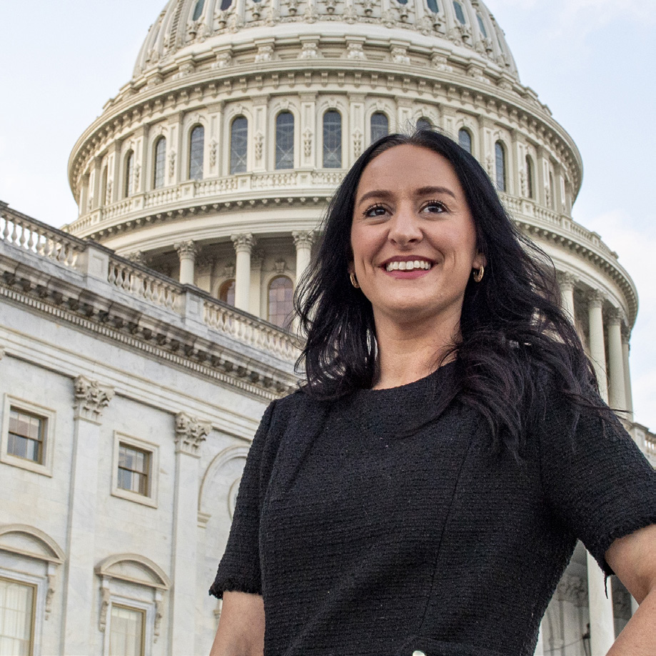 Woman in black outfit and hair, with the Tennessee state capitol building in the background.