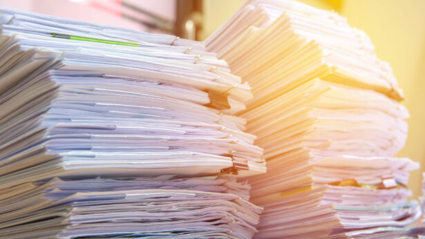 Piles of paperwork on a desk.