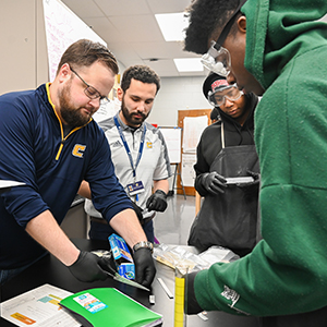 A group of four young men working on a engineering project.