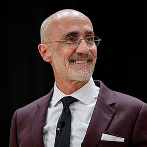 A balding white man with glasses and a suit.