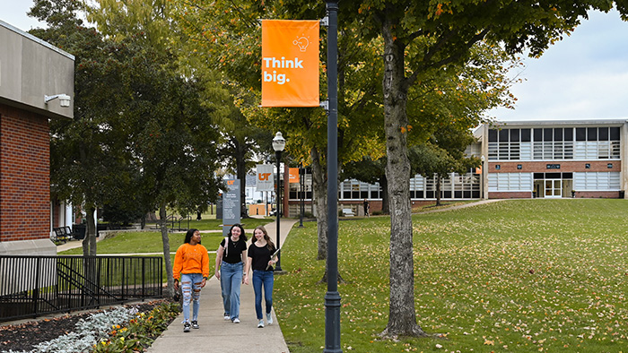 Three female students walk down a sidewalk on the UT Southern campus.