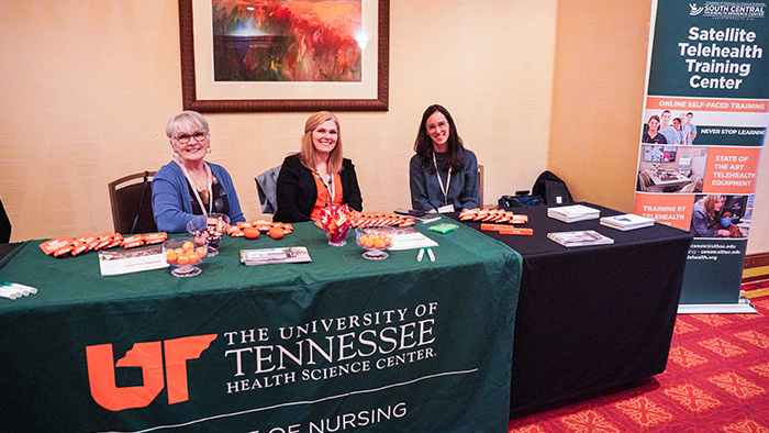 Three women sitting behind a table with UT Health Science Center hand-out materials.