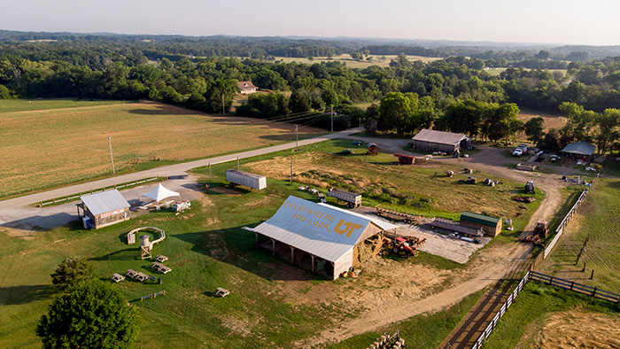 An aerial photo of a farm, with a barn roof painted with "Everywhere You Look, UT."