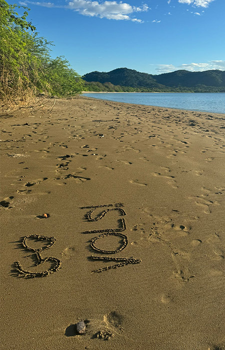 'Go Vols!' written in the sand of a Costa Rican beach.