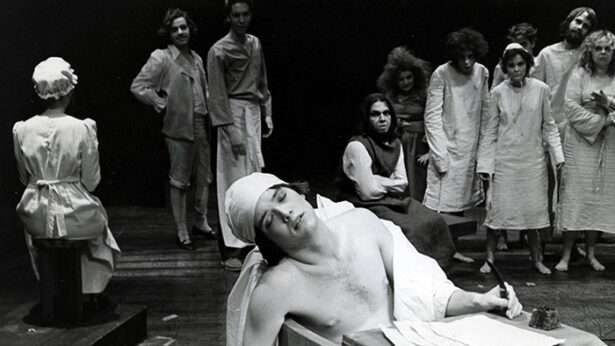 An old black and white photo of a group of actors participating in a theatre production.