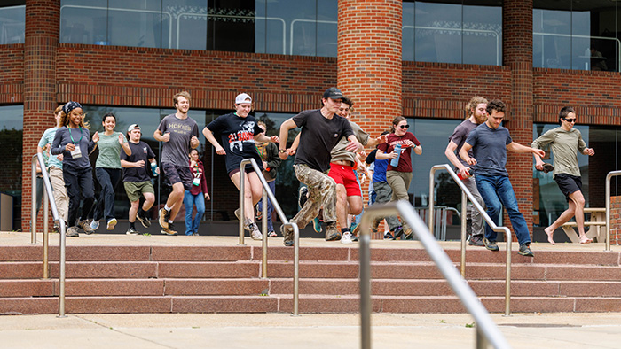 A group of students start running across campus during a team competition.