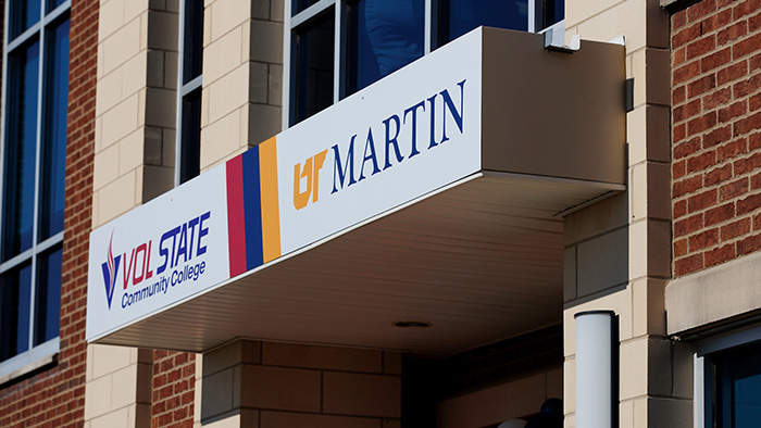 The entryway signage of a building, with printed lettering "Vol State Community College" and "UT Martin."