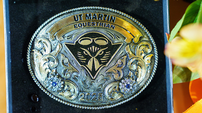 A large silver buckle-shaped trophy, with the UT Martin Captain Skyhawk emblem engraved.