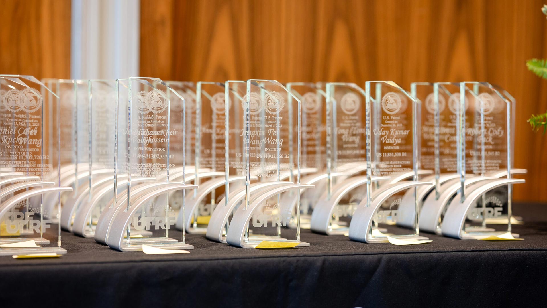 A table with rows of glass and metal award plaques sitting on top.