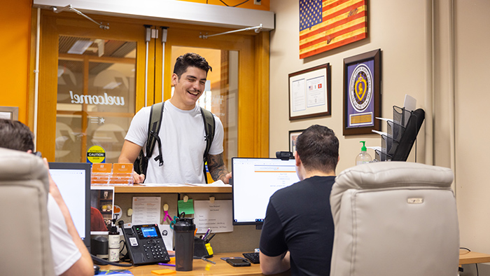 A young man talks with staff in a veteran's center.