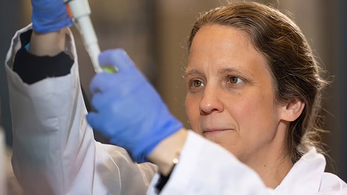 A woman using equipment inside a laboratory.
