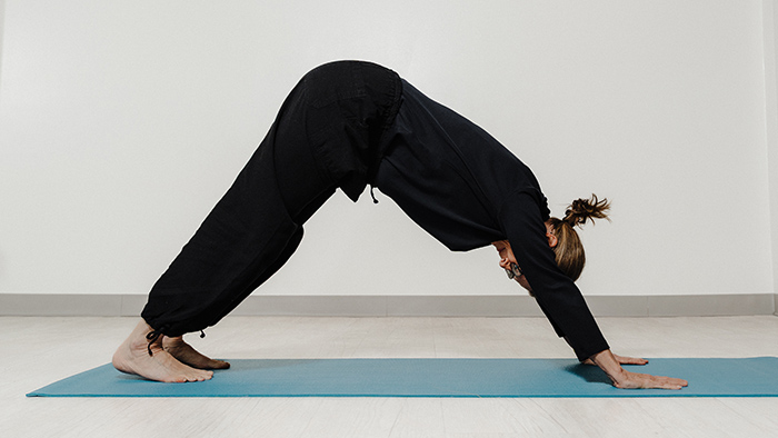 A woman doing the downward dog yoga pose.