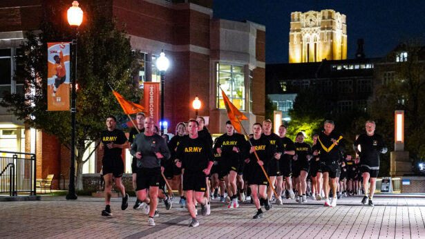 ROTC cadets running in formation during the early morning.
