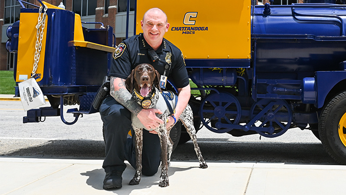 Police officer holding his K-9 partner.