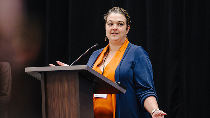 A woman speaking from behind a podium.
