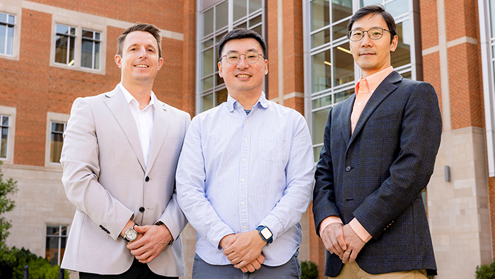 A group of three men posing for a photo.
