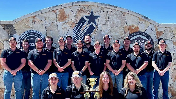 A group of people posing for a photo with a trophy.