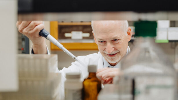 A man working with a pipette in a laboratory.
