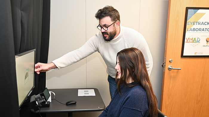 A man and woman looking at a computer screen.