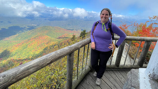 Woman on a mountain top lookout tower walkway.