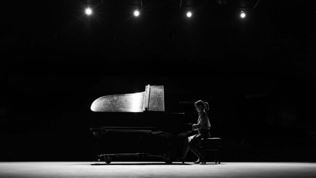 Woman playing a piano on stage.