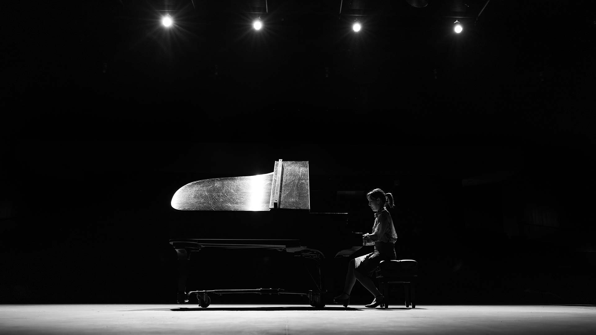 Woman playing a piano on stage.