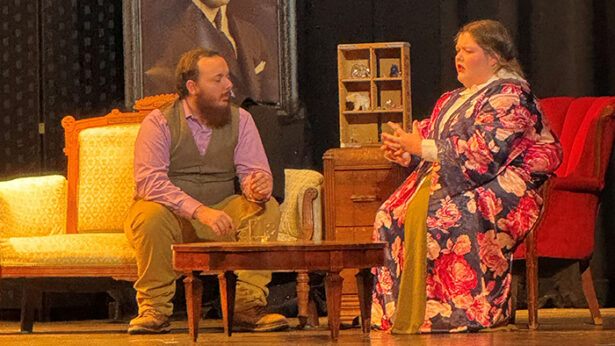 Two students acting on stage in a play.
