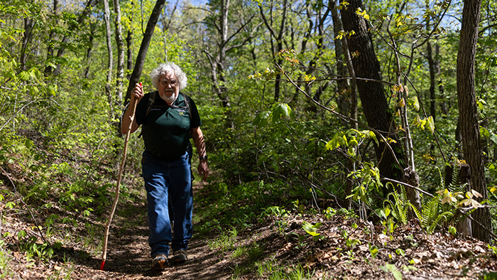 Man walking through a forest trail.