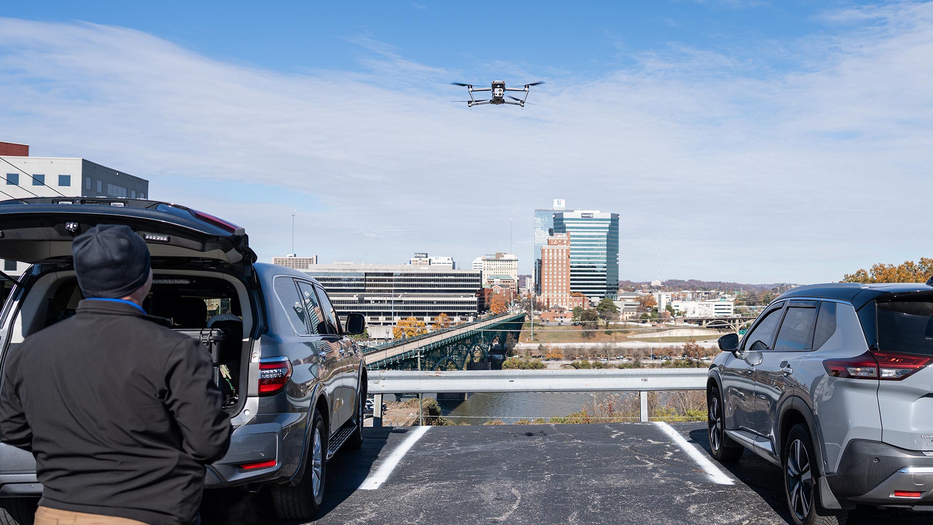A man in a parking lot piloting a drone.