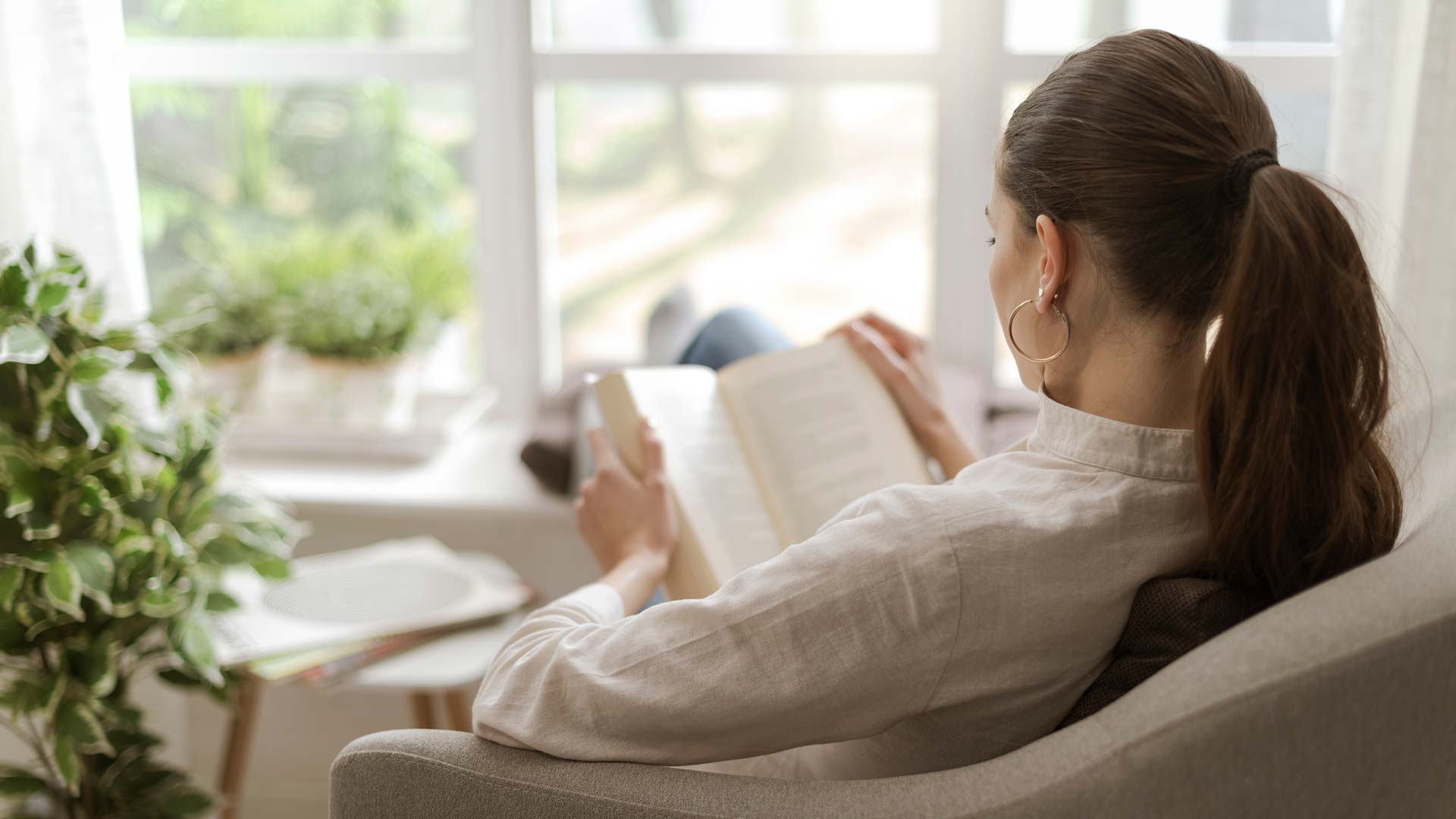 Woman lounging in a chair while reading.