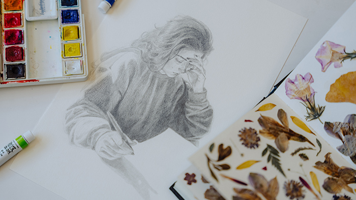 A pencil drawing of a girl holding a pen.