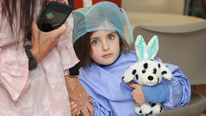 A small girl holding a stuffed animal.