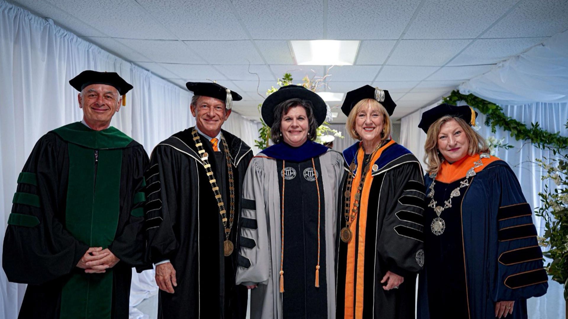 Group of people, all wearing commencement regalia.