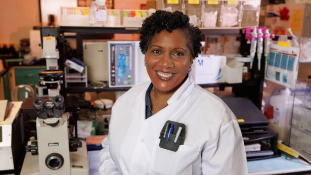 Woman smiling for a photo in a laboratory space.