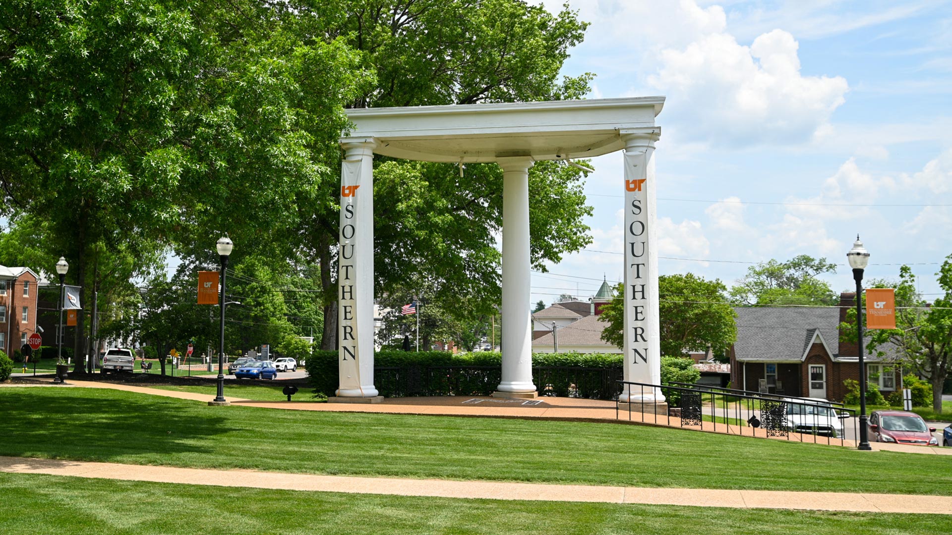 A pavilion with three large white columns, with vertical running banners with the text "UT Southern."