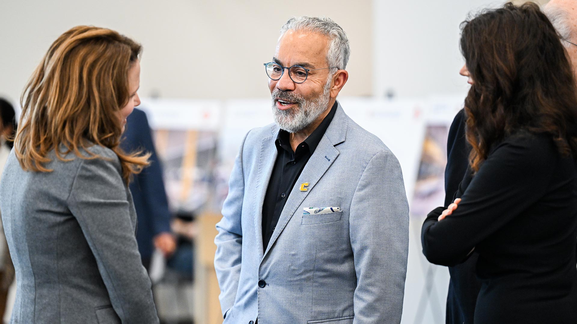 Three people talking together while attending an event.