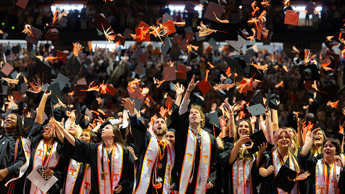 A group of college graduates throwing their caps into the air.