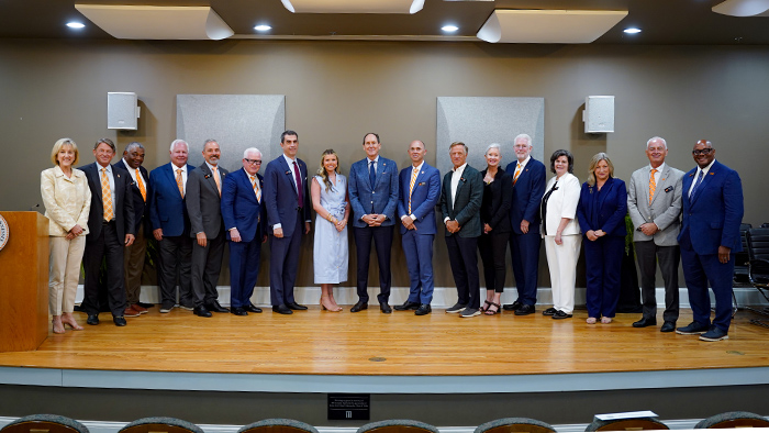A group of executives posing for a photo on a stage.